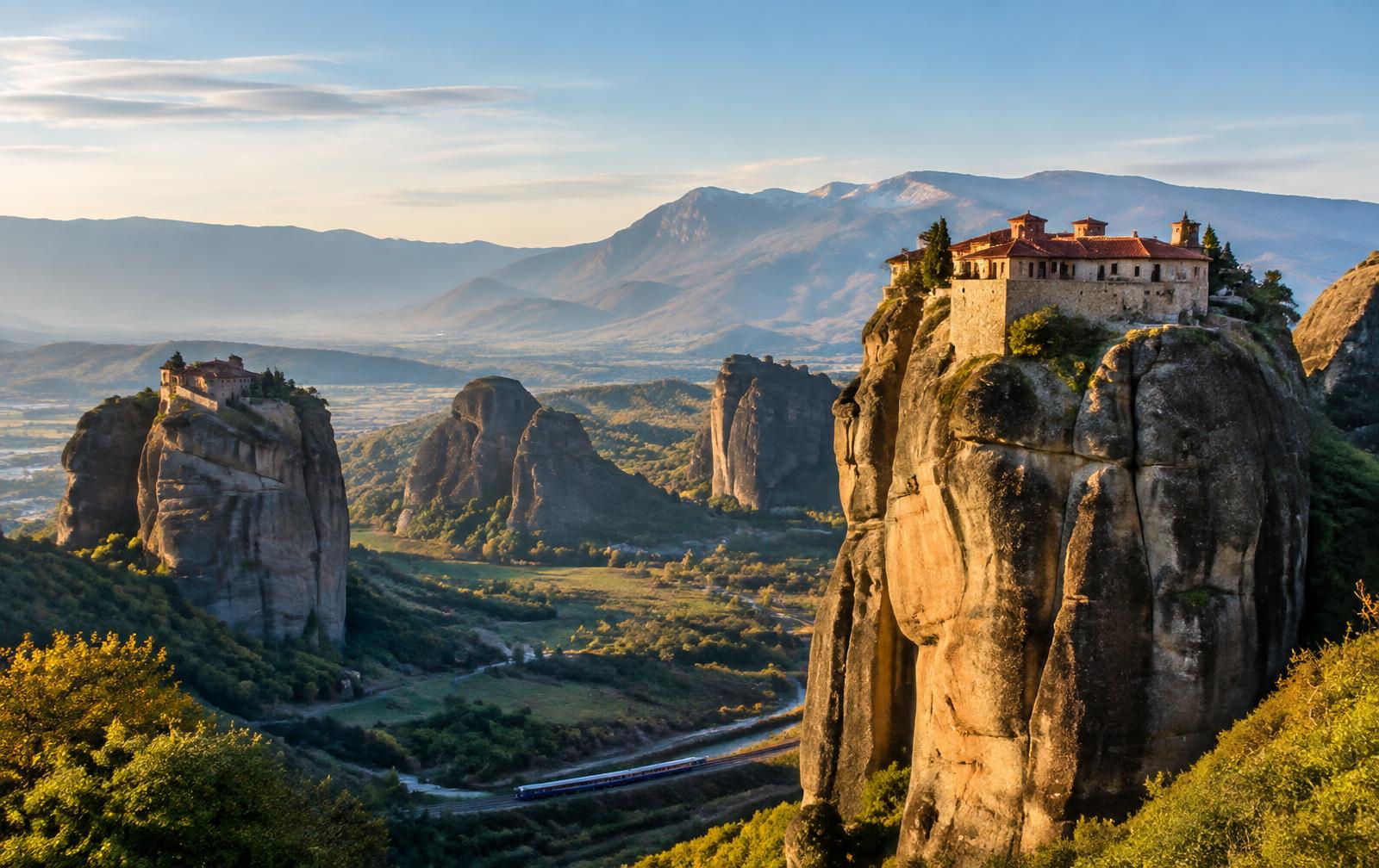 Meteora monasteries above the Thessaly plain with a train in the valley